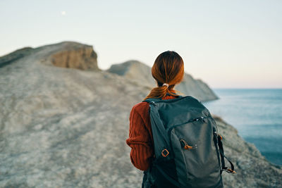 Rear view of woman looking at sea against sky