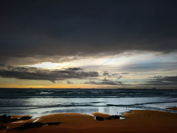 Scenic view of beach against sky during sunset