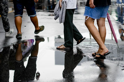 Low section of people walking on snow