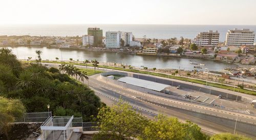 High angle view of city by sea against clear sky