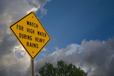 Low angle view of road sign against sky