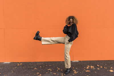 Woman dancing while standing on footpath