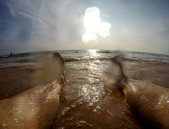 Close-up of swimming in sea against sky