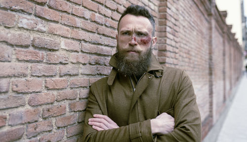 Portrait of man against brick wall