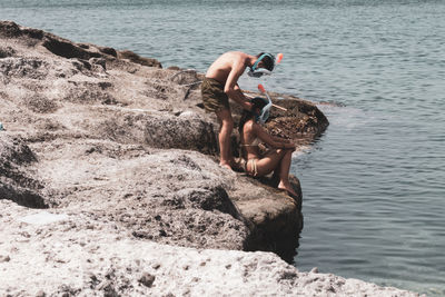 Woman standing on rock by sea