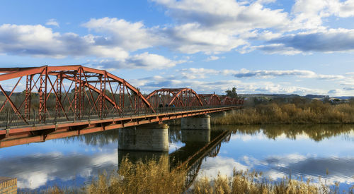 Arch bridge over river against sky