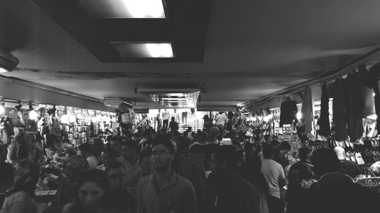 crowd, group of people, large group of people, illuminated, real people, men, women, night, architecture, adult, lighting equipment, city, lifestyles, market, built structure, city life, shopping, indoors, nightlife, consumerism, ceiling, street market