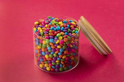 Colorful chocolate candy's, sugar coated chocolate gems candy on colorful background.