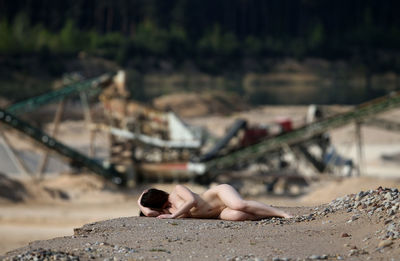 Sensuous naked female model lying on field