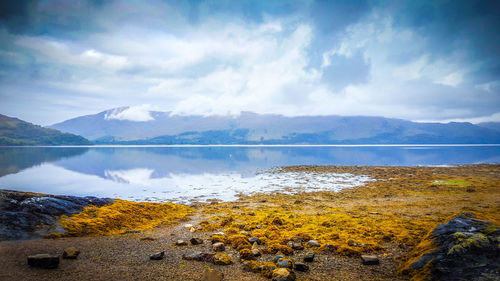 Scenic view of lake against cloudy sky