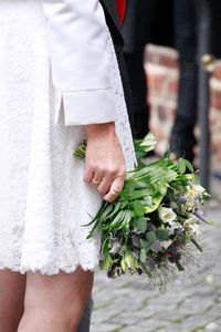 Midsection of woman holding flower bouquet