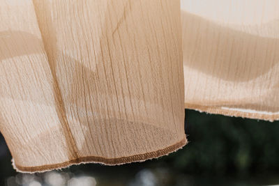 Close-up of flimsy curtain hanging on window