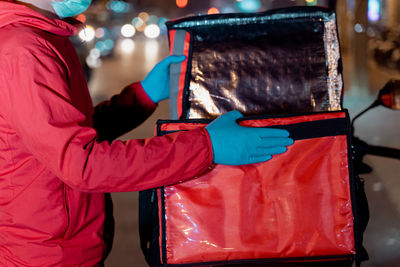 Midsection of woman holding christmas decorations at home