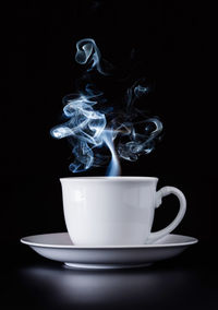 Close-up of coffee cup against black background