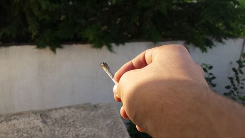 Close-up of hand holding cigarette