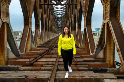Full length of young woman standing on railway