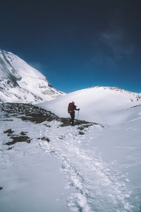 Man skiing on snowcapped mountain against sky