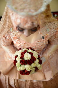 Midsection of woman holding rose bouquet