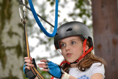 Adventure climbing high wire park - people on course in mountain helmet and safety equipment.