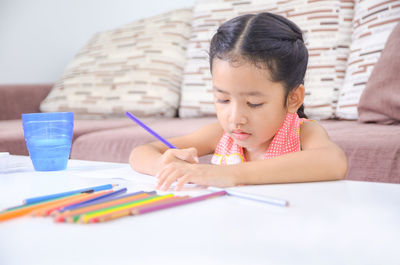 Girl coloring on paper at home