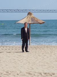 Full length portrait of man standing on beach