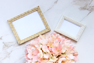 Picture frames and flower on table