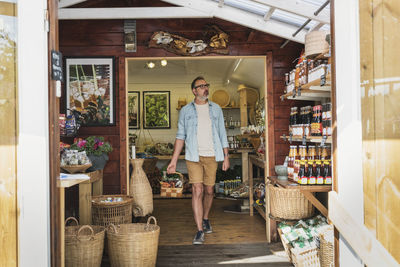 Mature man holding basket and walking while shopping in store