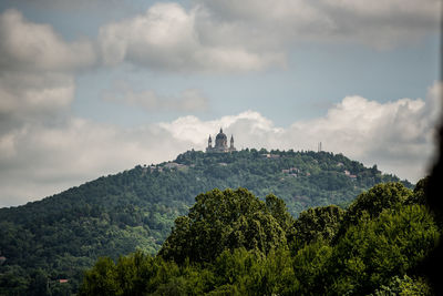 Panoramic view of trees and buildings against sky. the hill of superga with the church in turin