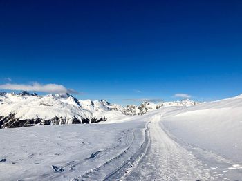 Scenic view of snowcapped mountains against blue sky