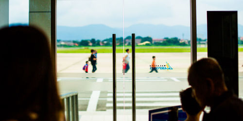 Rear view of people on glass window