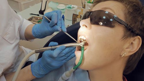 Cropped image of dentist operating patient in hospital