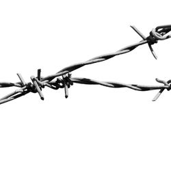 Low angle view of barbed wire against clear sky