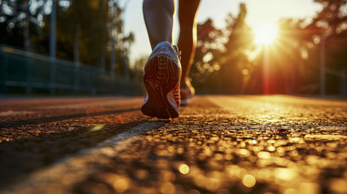 Slender legs in sneakers of a girl running in the rays of the rising sun. copy space 