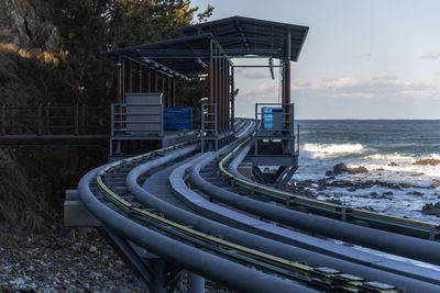 Scenic view of sea with mono rail station platform against sky