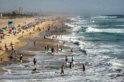 People enjoying on beach against sky