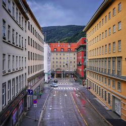 Road amidst buildings in city against sky