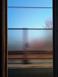 Blurred motion of train against clear sky seen through window