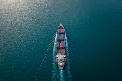 Containers ship corgo logistic transportation floating at sea aerial top view