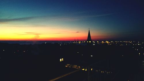 Illuminated cityscape against sky during sunset