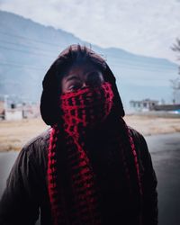 Portrait of man face covered with scarf against mountain