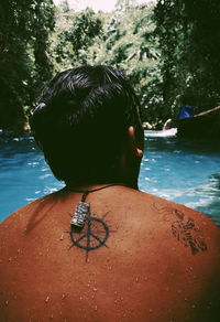 Rear view of man relaxing in swimming pool