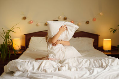 Midsection of man relaxing on bed at home