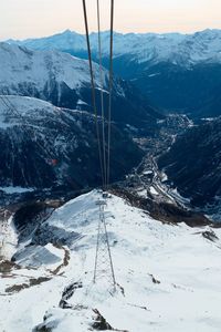 Overhead cable car on landscape against sky