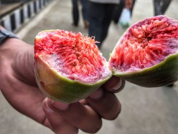 Cropped image of person holding fig