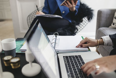 Midsection of female colleagues working at home office