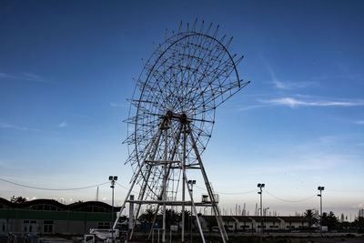 Low angle view of ferris wheel against blue sky