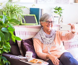 Midsection of woman using mobile phone while sitting on table