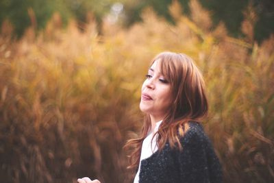 Woman looking away against plants