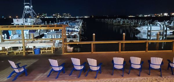 View of chairs in front of building at night