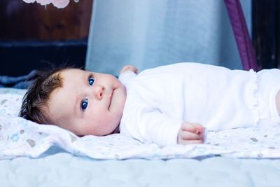 Portrait of cute baby lying on bed